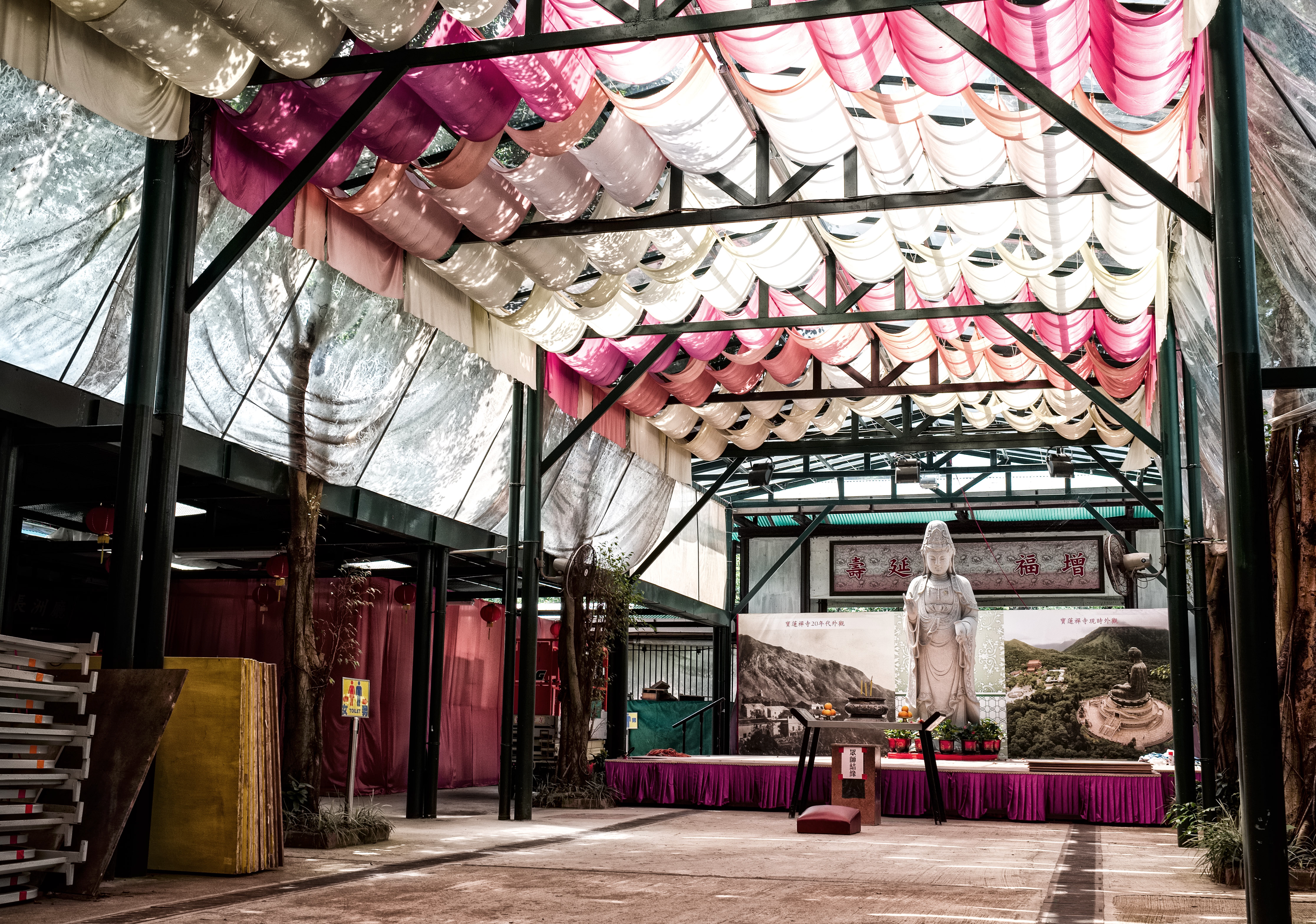 Temple interior with draped fabric ceiling and statue at the altar
